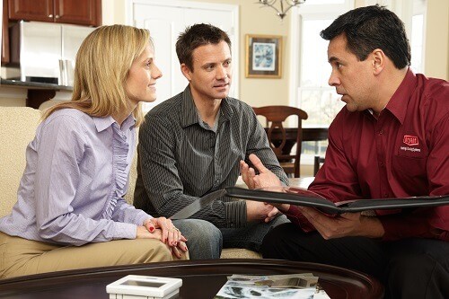 Couple discussing AC services with HVAC contractor