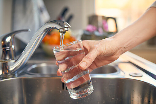 faucet pouring clean water from a water filter