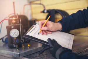 HVAC maintenance technician making notes about system