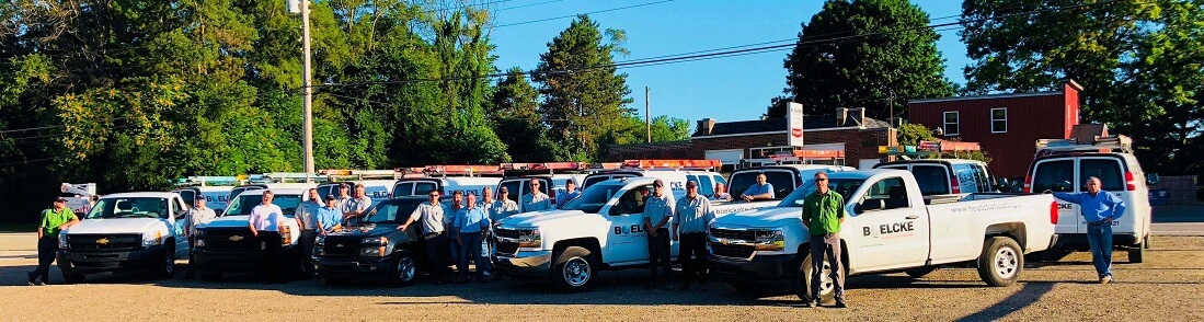 the boelcke hvac team posing by fleet of vehicles