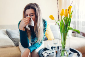 woman blows nose into tissue