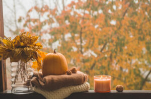 cozy fall window with leaves, pumpkin, and candle